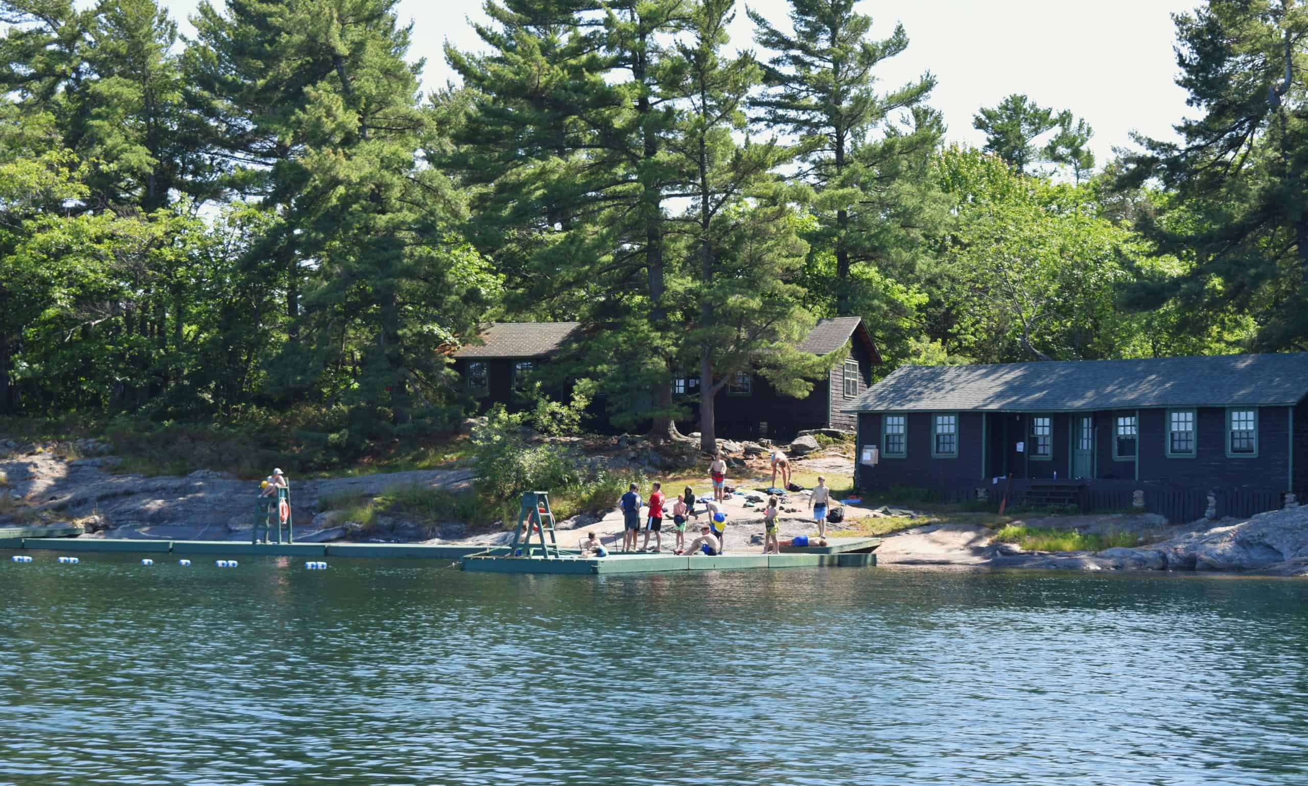 View of Camp Hurontario waterfront with dock and cabins in background